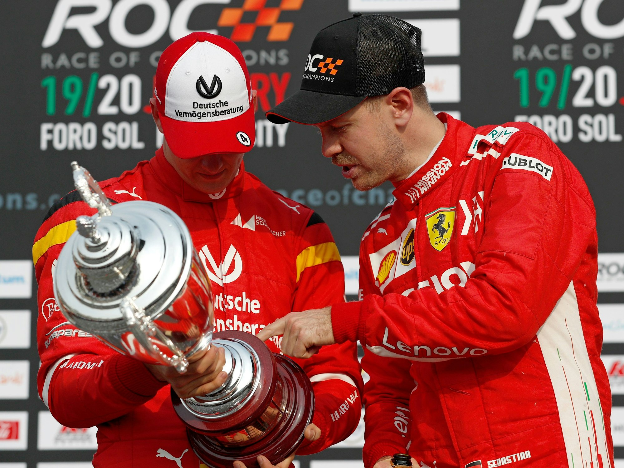 Sebastian Vettel (r) blickt während der Trophäenverleihung nach dem Race of Champions Nations Cup mit seinem Teamkollegen Mick Schumacher auf ihre Trophäe für den zweiten Platz.