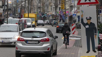 Autos fahren auf der Venloer Straße, auch Fahrräder sind unterwegs, es ist ziemlich voll.