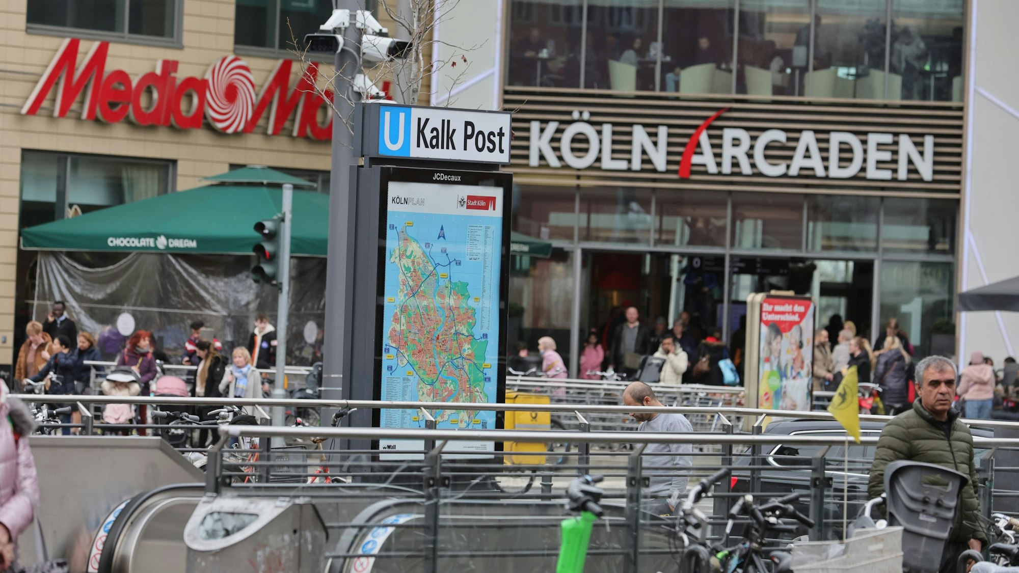Die Polizei beobachtet mit Videokameras den Bereich vor den Köln Arcaden. Das Foto zeigt die Rolltreppen zur Station, den Eingang zum Einkaufszentrum und die Beobachtungskameras der Polizei.