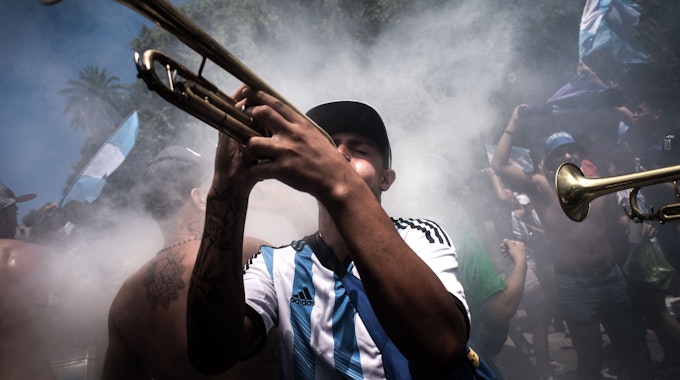 Nach der Ankunft von Weltmeister Argentinien in der Heimat: Fußballfans spielen Musik, während sie auf die argentinische Fußballmannschaft warten.