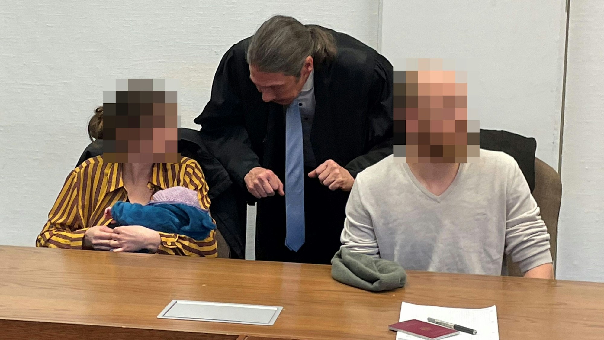 Die Angeklagten mit Baby und Verteidiger Ingo Lindemann beim Prozess vor dem Kölner Amtsgericht.