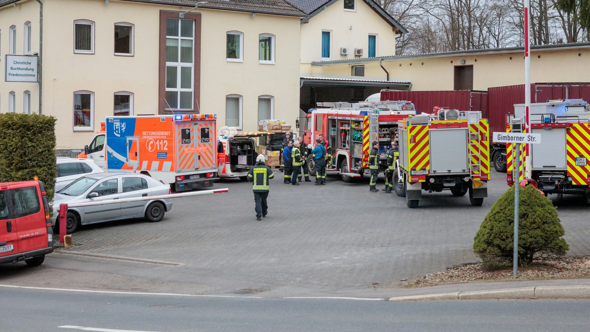 Fahrzeuge der Feuerwehr und des Rettungsdienstes stehen vor einem Gebäude.