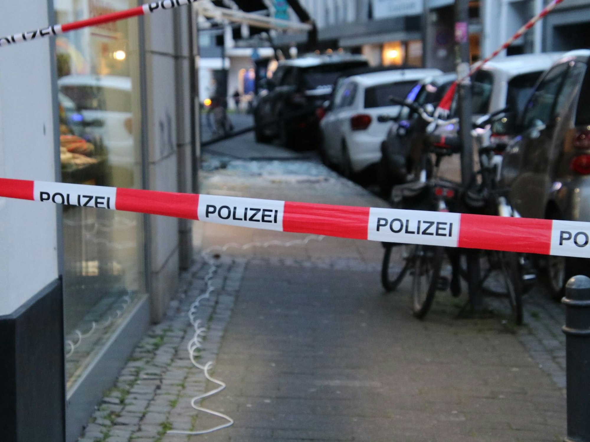 Der Eingangsbereich des Juweliergeschäfts „Cologne Watch“ in der Benisisstraße wurde gesprengt. Auf dem Boden liegt ein weißes Kabel.