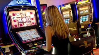Eine Frau bedient in einer Spielhalle einen Automaten.