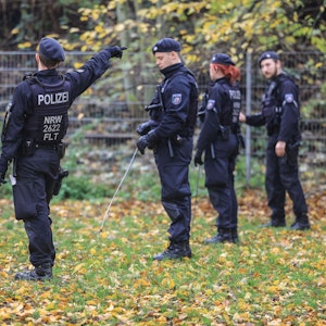 Polizisten suchen mit Eisenstangen, hier im November 2022 in Krefeld, eine Wiese ab.