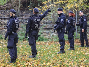 Polizisten suchen mit Eisenstangen, hier im November 2022 inKrefeld, eine Wiese ab.