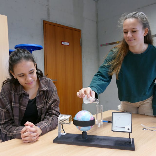 Zwei Schülerinnen an einem Klimatestgerät.