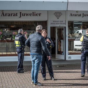 Polizisten und Zivilisten stehen vor dem Juwelier Ararat in Wiesdorfs City B.