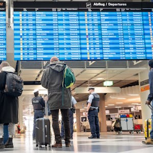 Passagiere informieren sich in der Abflughalle an einer Anzeigetafel. Am Flughafen München findet angesichts der angekündigten Warnstreiks am kommenden Sonntag und Montag kein regulärer Passagier- und Frachtverkehr statt.