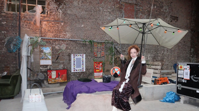 Eine Frau sitzt inmitten einer Kunst-Installation.