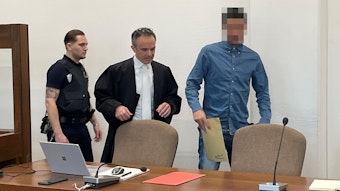 Der Angeklagte beim Prozessauftakt im Landgericht Köln. Links ein Wachtmeister und der Verteidiger.