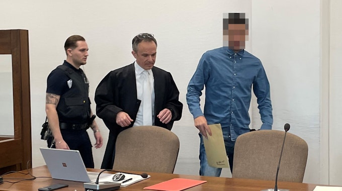 Der Angeklagte beim Prozessauftakt im Landgericht Köln. Links ein Wachtmeister und der Verteidiger.