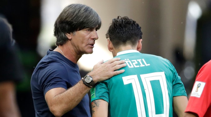 Trainer Joachim Löw aus Deutschland spricht an der Seitenlinie mit seinem Spieler Mesut Özil.