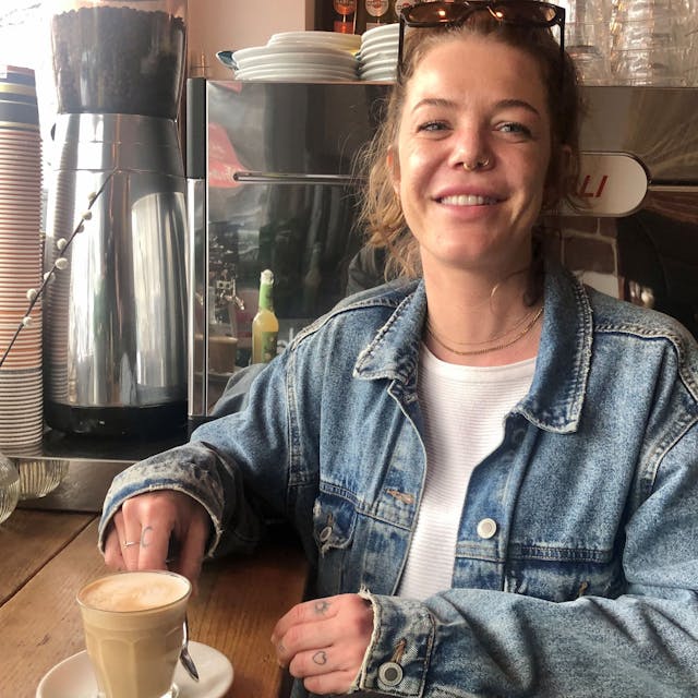 Junge Frau mit Cappuccino im Café