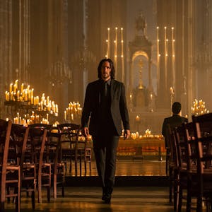 Keanu Reeves als John Wick geht in einer Szene des Spielfilms „John Wick: Kapitel 4“ durch eine von Kerzen beleuchtete Kirche.