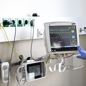 Eine Pflegerin schaut in einem Krankenzimmer im Klinikum Stuttgart auf einen Monitor einer Patientin.