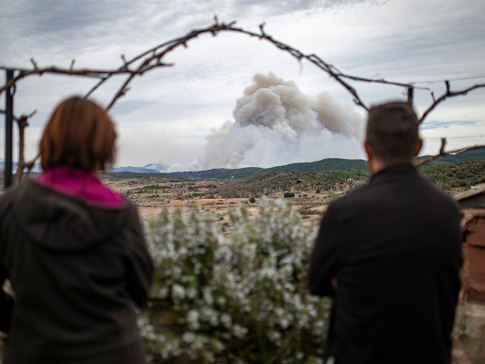 Freitag, 24. März: Zwei Personen beobachten die Rauchwolke, die von San Agustin (Aragonien) aus zu sehen ist. Der erste größere Waldbrand des Jahres in Spanien hat im Osten des Landes bereits mehr als Tausend Hektar zerstört.