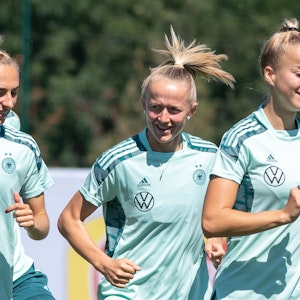 Lea Schüller (M) läuft im Training der deutschen Frauen-Nationalmannschaft hinter Sophia Kleinherne (l) und Giulia Gwinn her.
