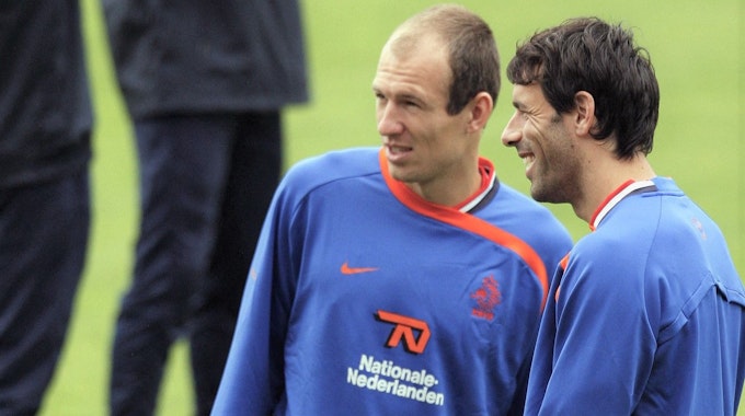 Arjen Robben (l.) und Ruud van Nistelrooy stehen im Training der niederländischen Nationalmannschaft nebeneinander und sprechen.