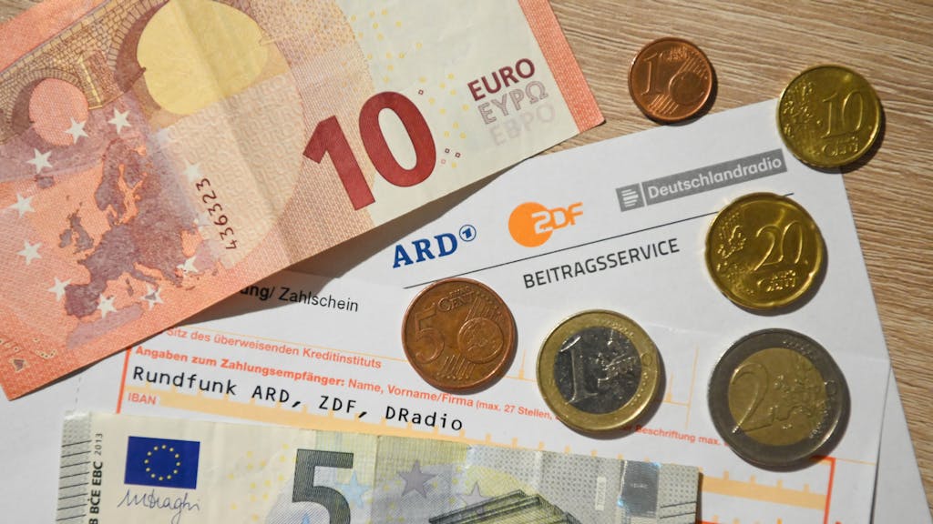 18,36 Euro liegen in Scheinen und Münzen rund um ein Schreiben und einen Überweisungsträger zum Rundfunkbeitrag.