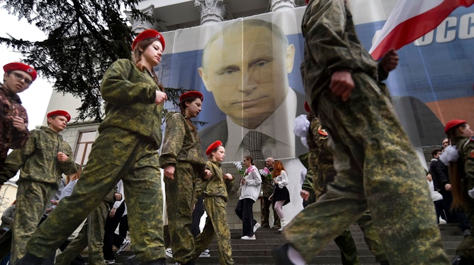 Uniformierte Jugendliche marschieren in Jalte anlässlich einer Aktion zum neunten Jahrestag der Krim-Annexion an einem Bildnis des russischen Präsidenten Wladimir Putin vorbei.(Archivbild)