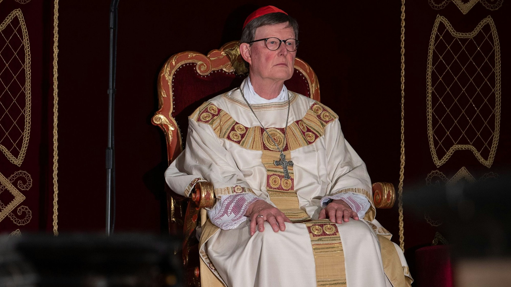Kardinal Rainer Woelki sitzt während eines Gottesdienstes im Dom zu Fulda während der Herbstvollversammlung der Deutschen Bischofskonferenz 2022 auf einem barocken Stuhl.