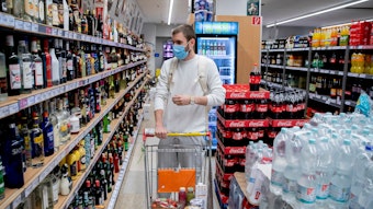 Ein Kunde geht in einem Supermarkt in Berlin-Wilmersdorf mit Mund-Nasen-Schutz einkaufen.