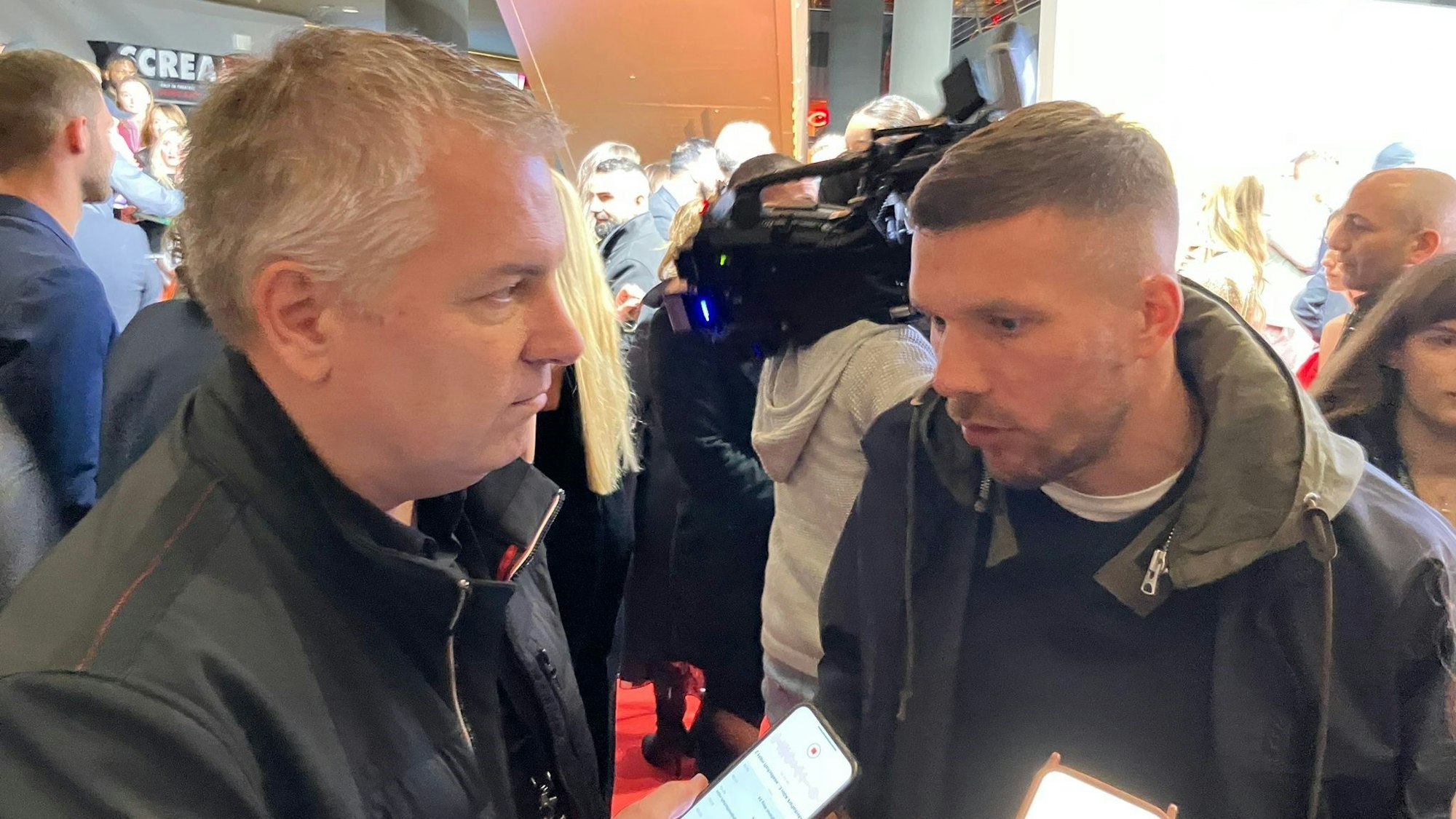 Lukas Podolski spricht mit Marcel Schwamborn.