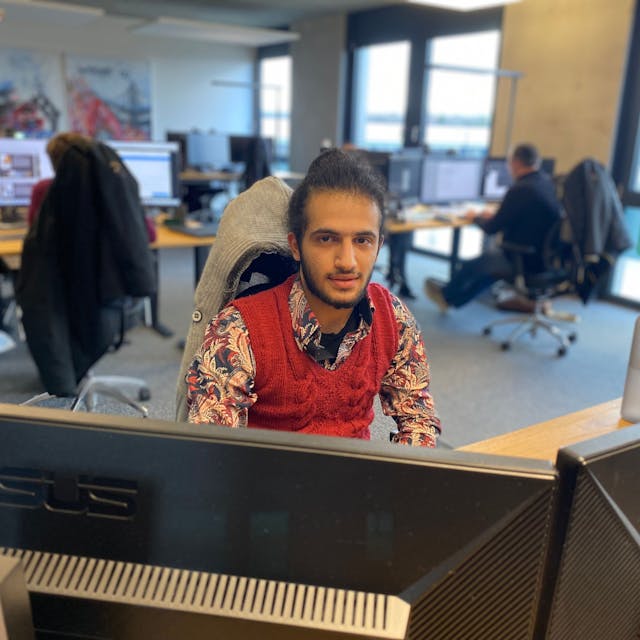 Der 21-jährige Mustapha Attar sitzt an einem der Arbeitsplätze in der Werbeagentur Lemm.