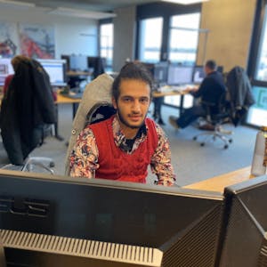 Der 21-jährige Mustapha Attar sitzt an einem der Arbeitsplätze in der Werbeagentur Lemm.