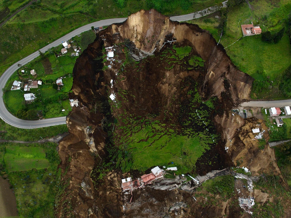Ein riesiges Loch klafft mitten in der Landschaft von Ecuador. Durch einen regenbedingten Erdrutsch sind Häuser und Straßen eingebrochen.
