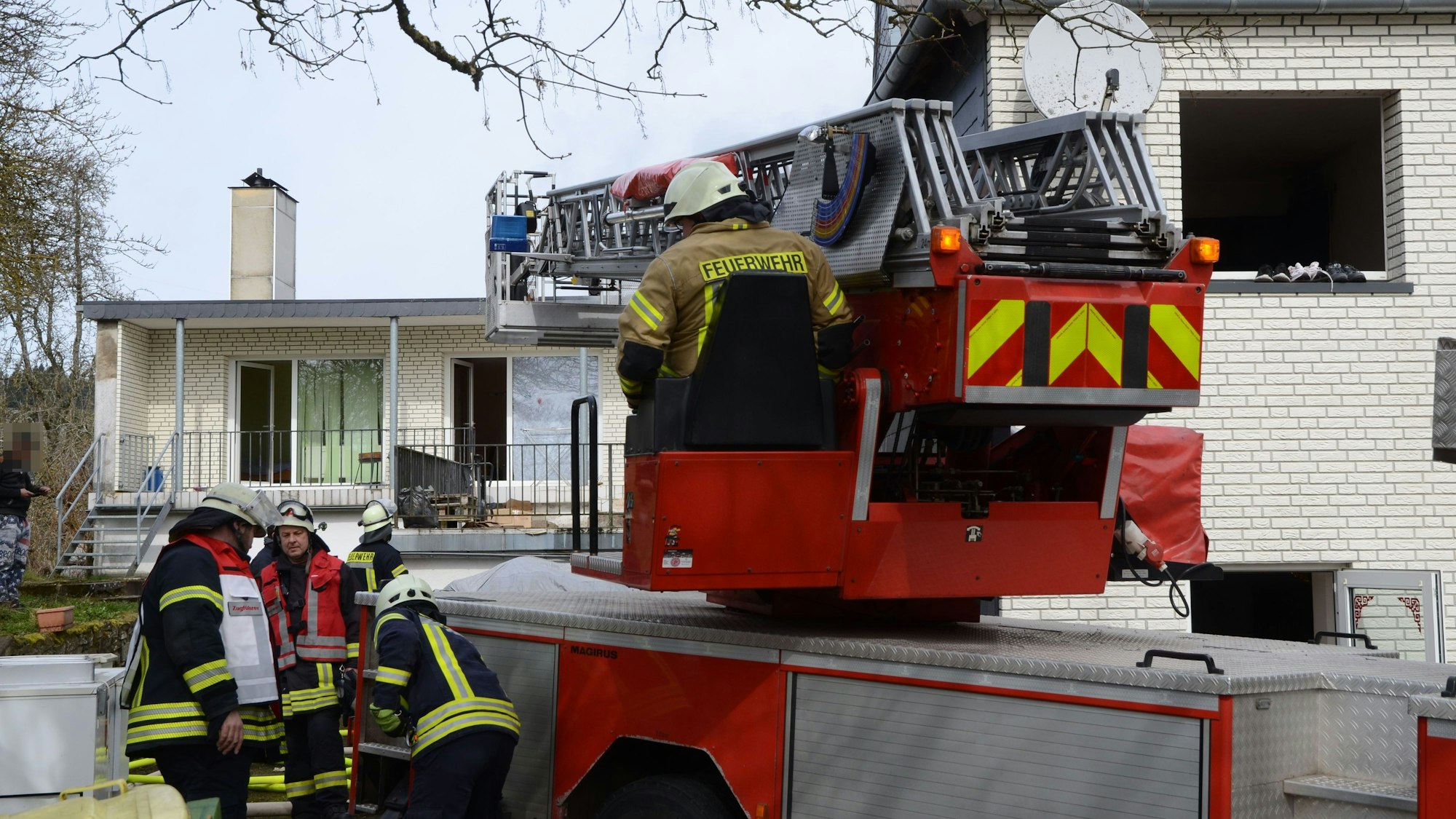 Eine Drehleiter der Feuerwehr steht vor dem Haus, in dem es gebrannt hat.