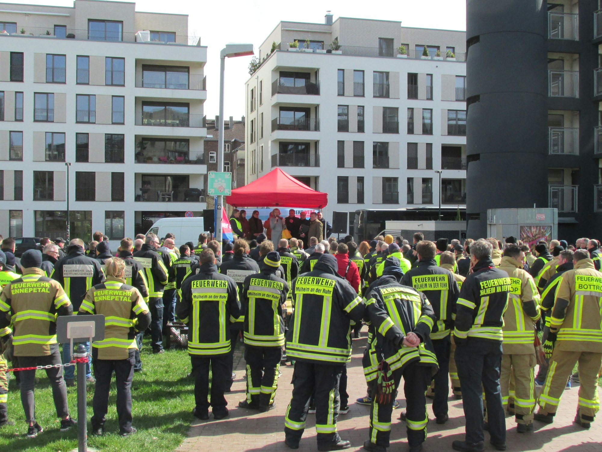 Feuerwehrleute stehen vor einem Zelt vor dem Landtag NRW.