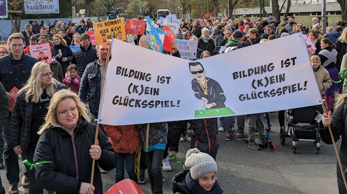 Das Bild zeigt mehrere Demonstranten mit Plakaten auf dem Weg zum Rathaus.