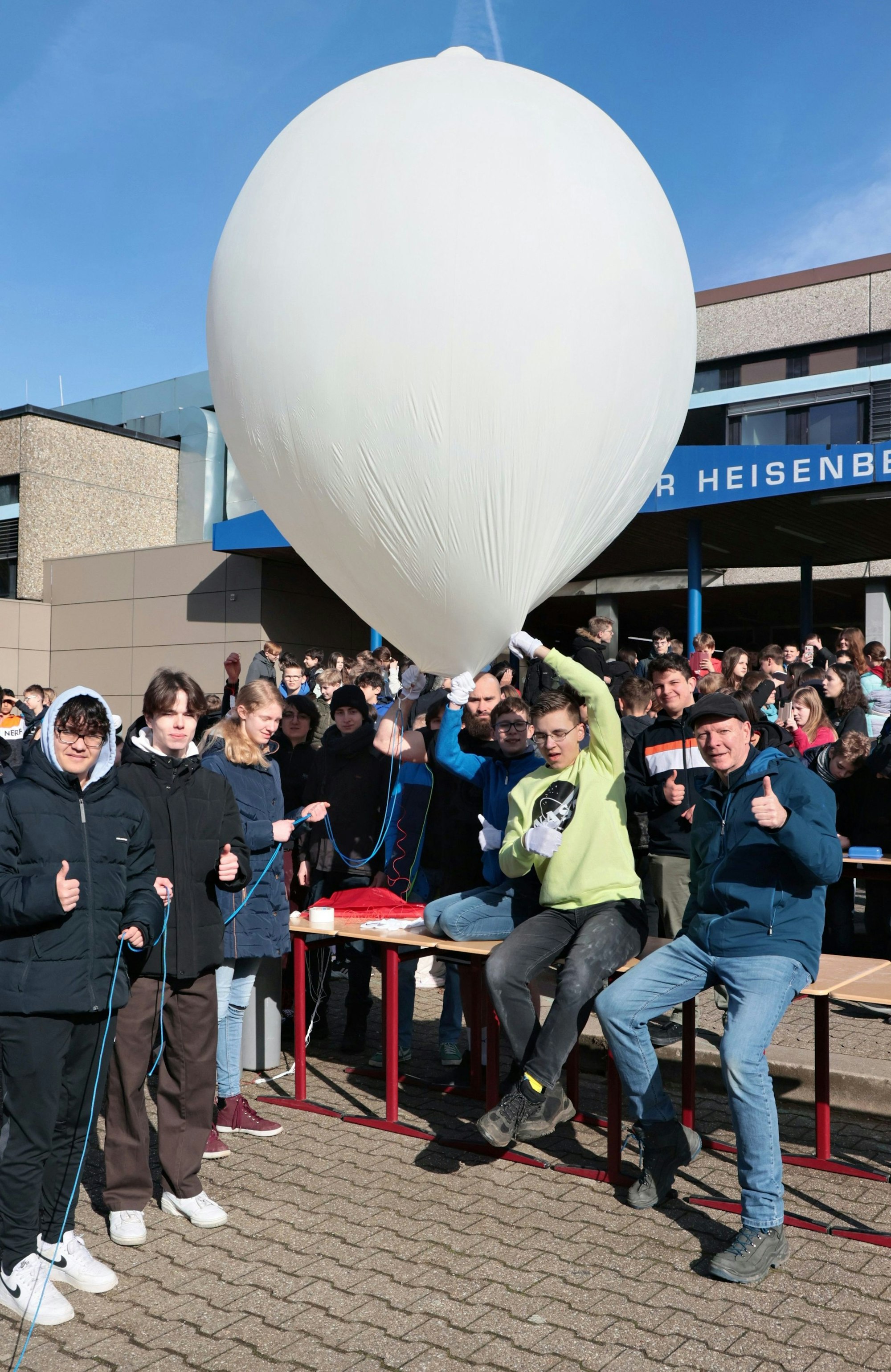 Schüler und Lehrer mit dem Ballon auf dem Schulhof