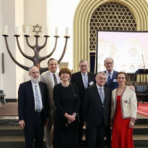 Verschiedene Funktionäre stehen in einer Synagoge