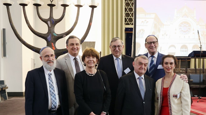 Verschiedene Funktionäre stehen in einer Synagoge