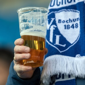 Ein Fan hält seinen Becher mit Bier in der Hand.