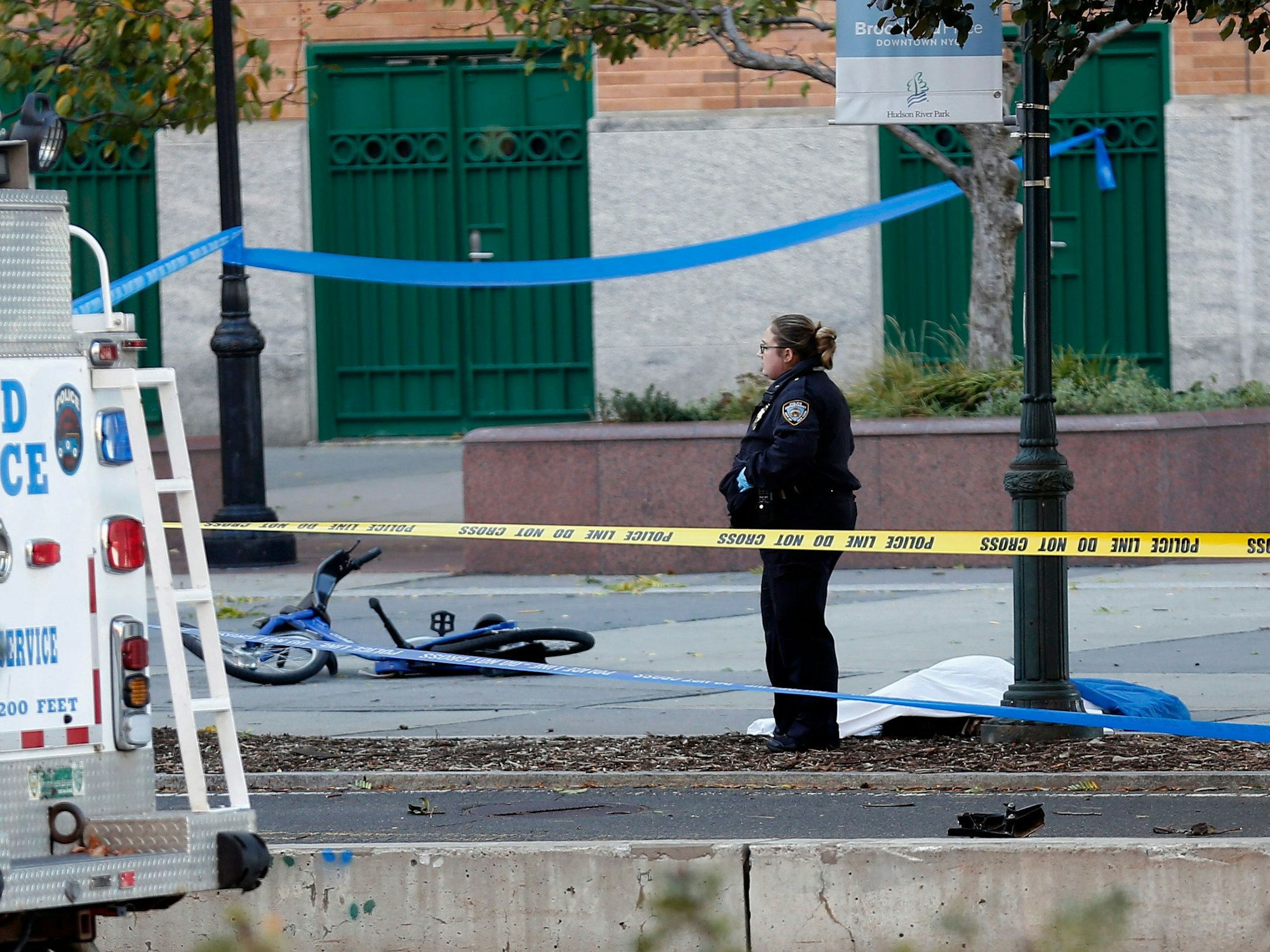 Eine Polizistin steht im Oktober 2017 in New York (USA) auf einem Fahrradweg neben einem abgedeckten Körper und einem beschädigten Fahrrad.