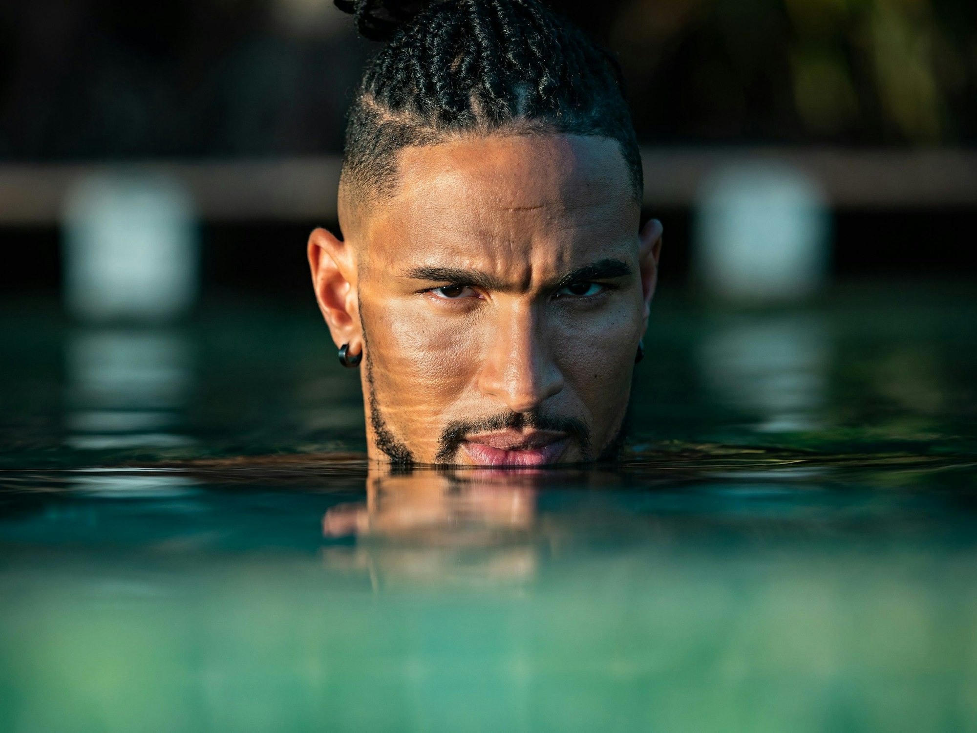 „Bachelor“ David Jackson schaut grimmig aus dem Wasser eines Pools.