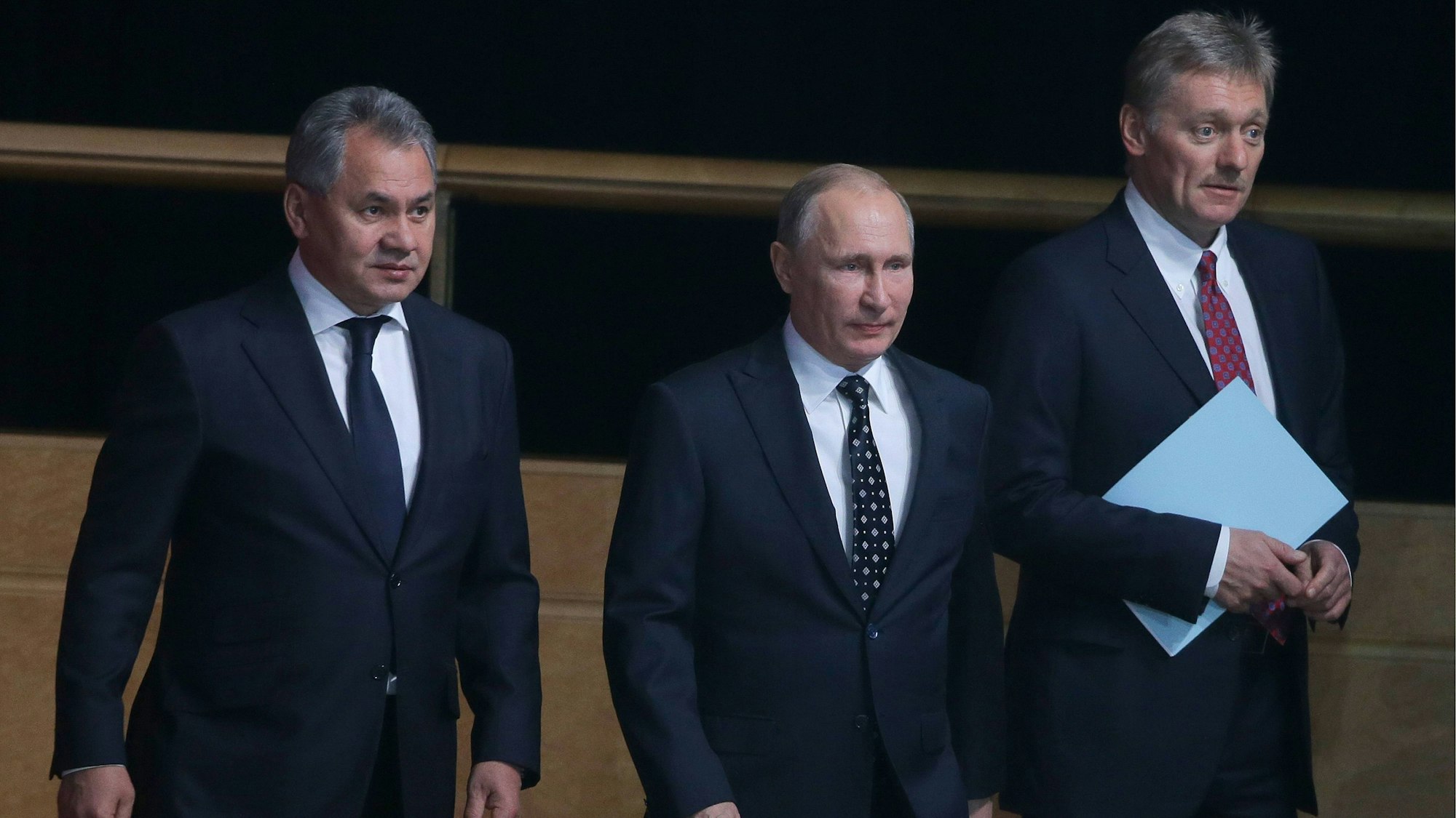 Wladimir Putin (m.) zusammen mit Verteidigungsminister Sergei Schoigu (l.) und Kremlsprecher Dmitri Peskow (r.). Die drei Politiker scheinen Russland auf einen langwierigen Krieg vorbereiten zu wollen. (Archivbild)