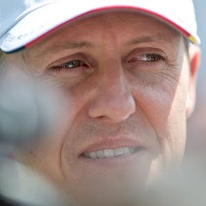 Der deutsche Formel-1-Pilot Michael Schumacher blickt lächelnd in die Kamera. Er trägt eine Kappe seines Teams Mercedes.