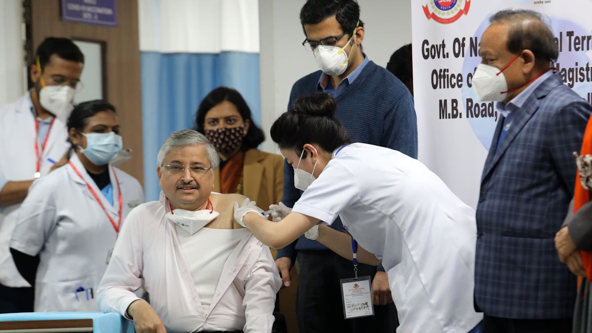 Ein Medizinischer Mitarbeiter wird im All India Institute of Medical Science von einer Krankenschwester mit dem Corona-Impfstoff geimpft.