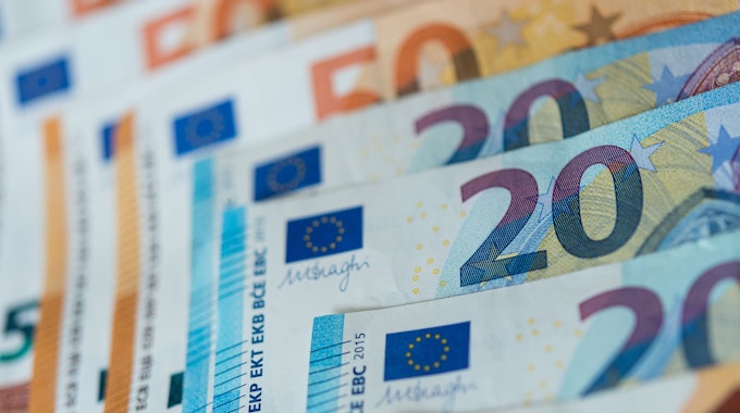 Zahlreiche Banknoten von 10, 20 und 50 Euro liegen sortiert auf einem Tisch.