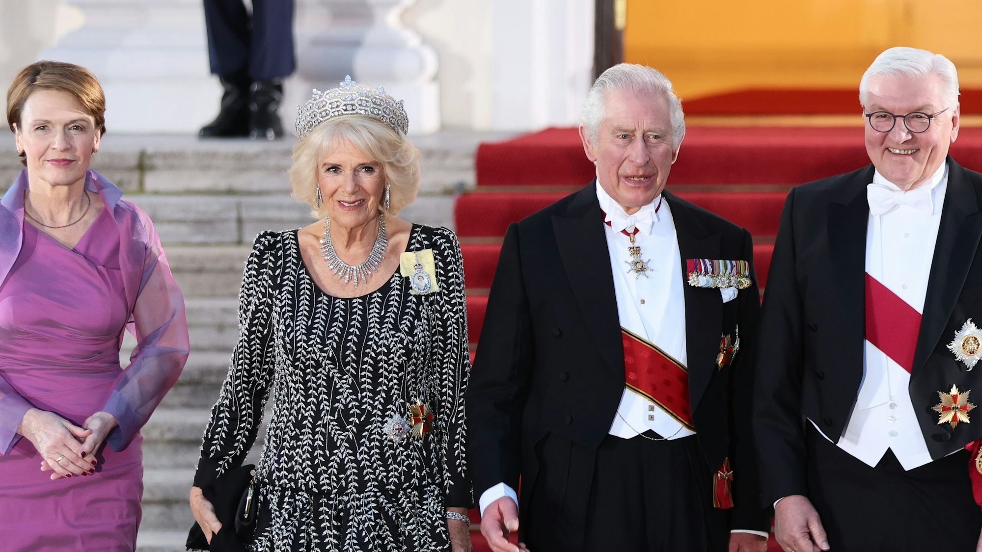 König Charles III. und Königin-Gemahlin Camilla kommen mit Bundespräsident Frank-Walter Steinmeier und seiner Frau Elke Büdenbender die Treppe herunter.