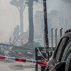 Trümmer liegen nach der Explosion auf der verrauchten Augustastraße in Opladen.