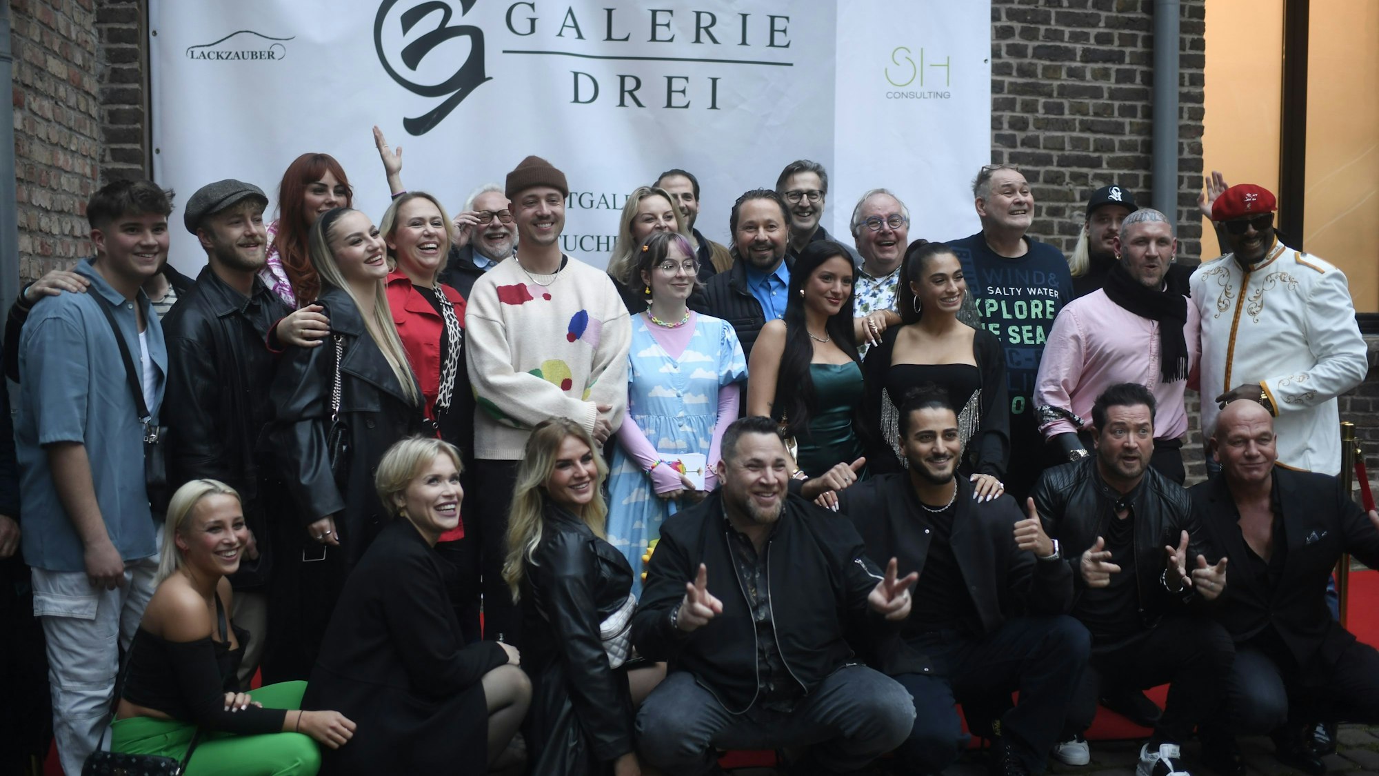 Künstler, Influencer und Reality-TV-Sternchen kamen zur Eröffnung. Sie posieren für ein Gruppenfoto.