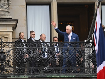 König Charles III. von Großbritannien winkt vom Balkon des Hamburger Rathauses.