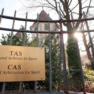 Außenansicht vom Internationalen Sportgerichtshof (CAS) in der schweizerischen Stadt Lausanne. Ein metallenes Schild hängt an einem Eisenzaun.