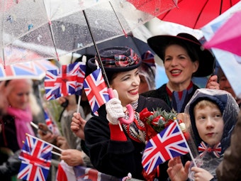 Royal-Fans warten bei Regen am Rathausmarkt vor dem Hamburger Rathaus auf die Ankunft des britischen Königspaares.